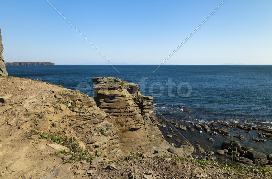 Rocks and sea meet in the bright sunlight in autumn