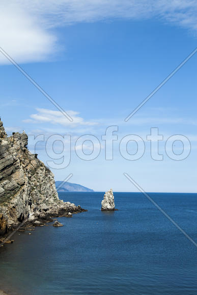 Mountains by the sea in beams of a bright sun