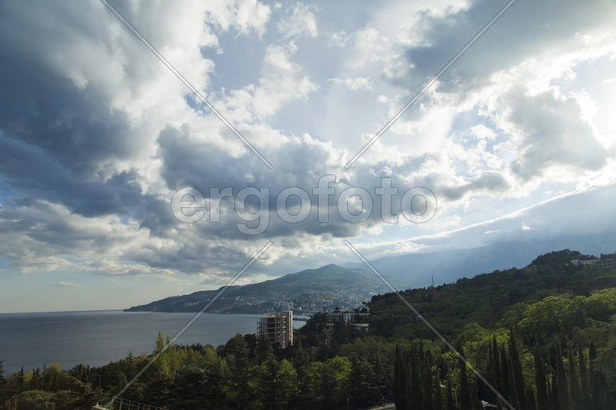 Clouds over mountains majestically float towards the sea