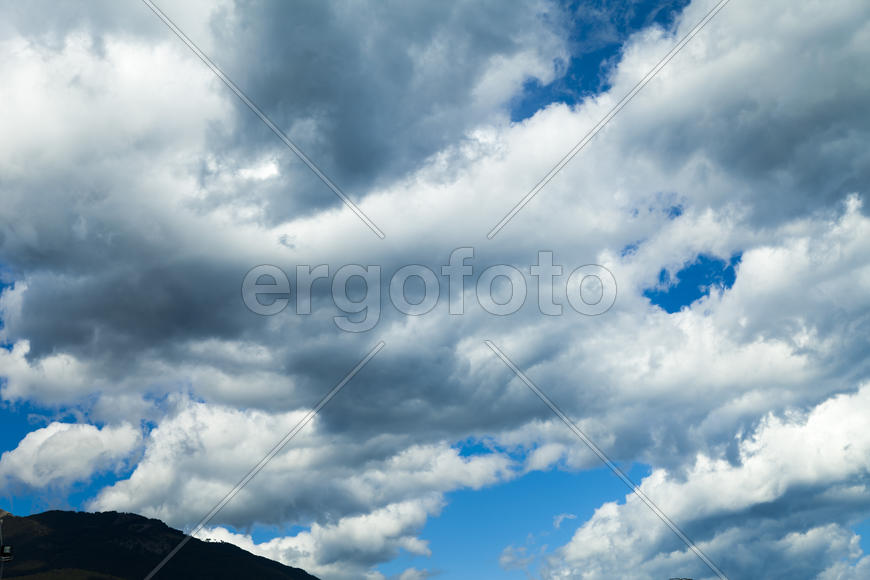 Clouds over mountains majestically float towards the sea