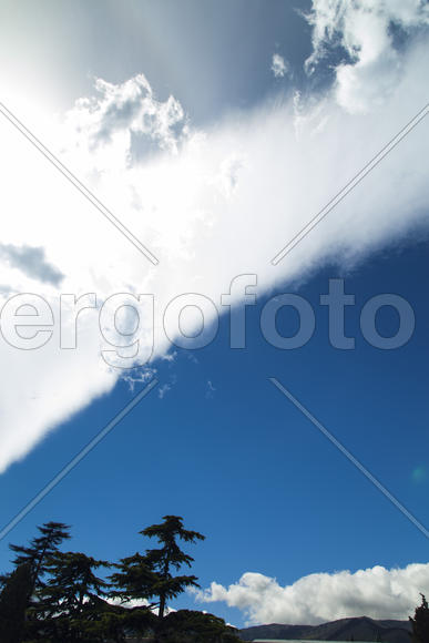 Clouds over mountains majestically float towards the sea