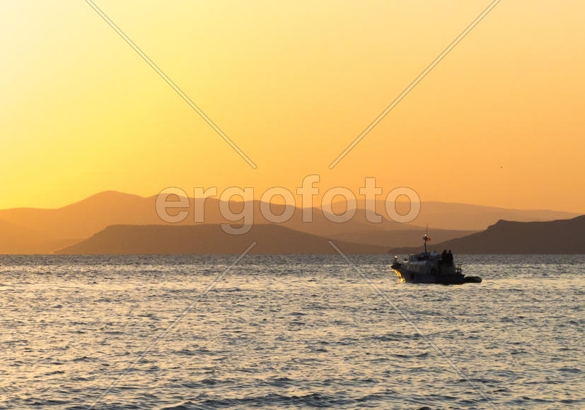 The sea at sunset in beams of the red setting sun
