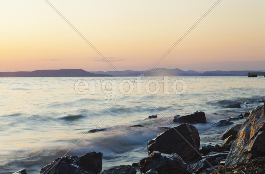 The sea at sunset in beams of the red setting sun