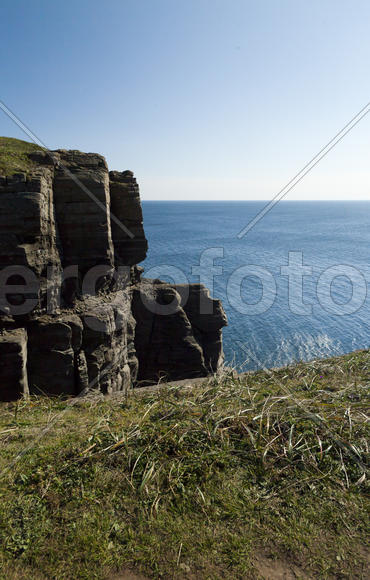 Rocks and sea meet in the bright sunlight in autumn