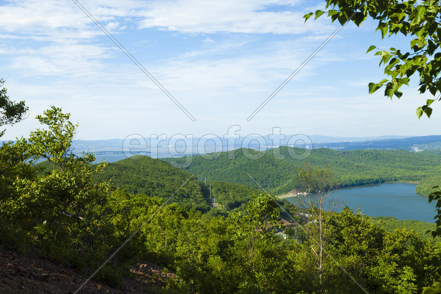 Green hills under the blue sky in beams of a bright sun