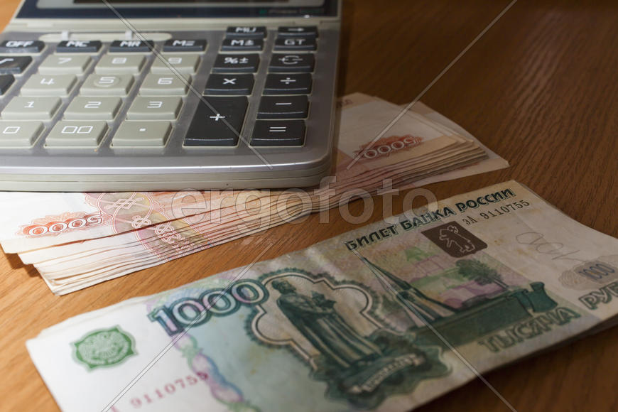 The roll of money on a table lies on pleasure to the owner