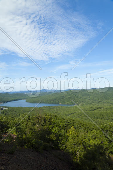 Green hills under the blue sky in beams of a bright sun