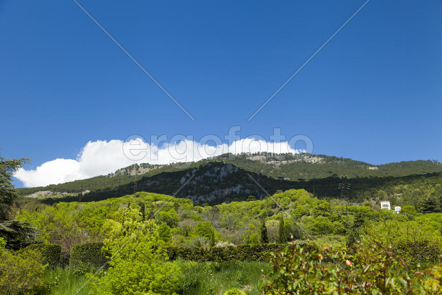 Clouds over mountains majestically float towards the sea