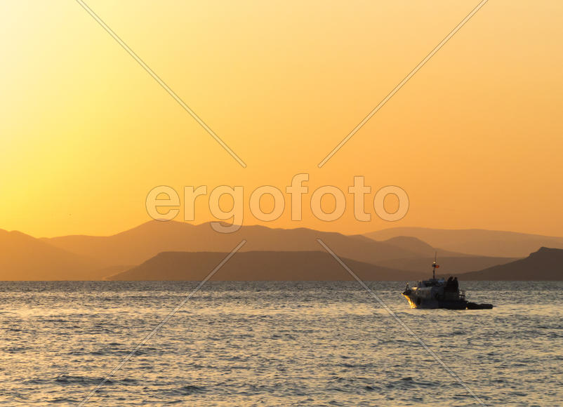 The sea at sunset in beams of the red setting sun