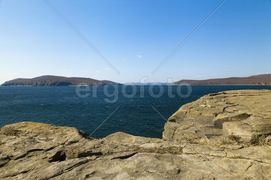 Rocks and sea meet in the bright sunlight in autumn