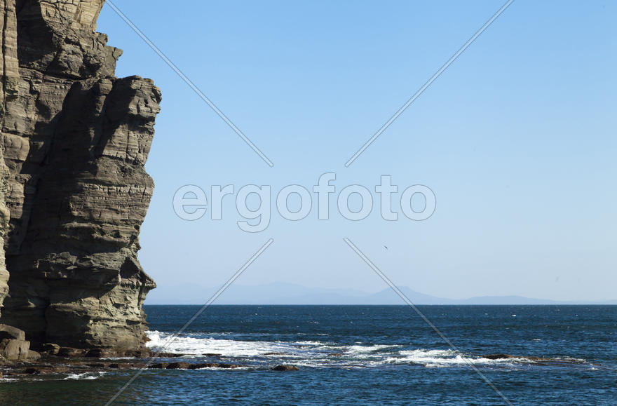 Rocks and sea meet in the bright sunlight in autumn