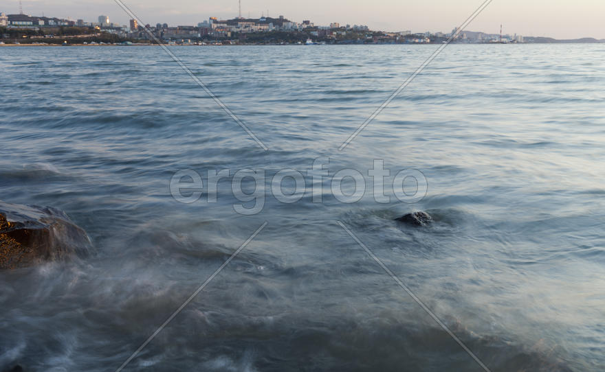The sea at sunset in beams of the red setting sun