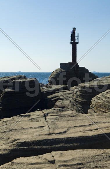 Rocks and sea meet in the bright sunlight in autumn