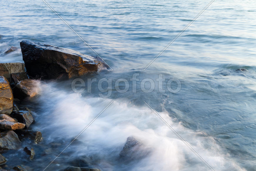The sea at sunset in beams of the red setting sun