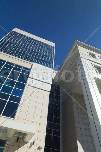 Modern building against the blue sky in the rays of bright sunshine