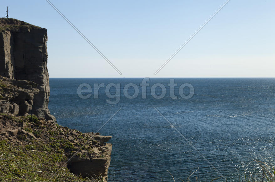 Rocks and sea meet in the bright sunlight in autumn
