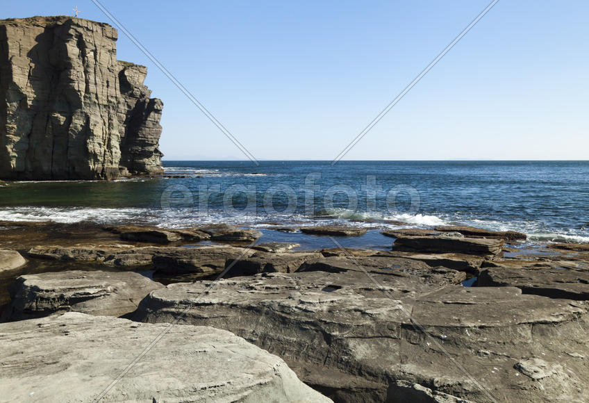 Rocks and sea meet in the bright sunlight in autumn
