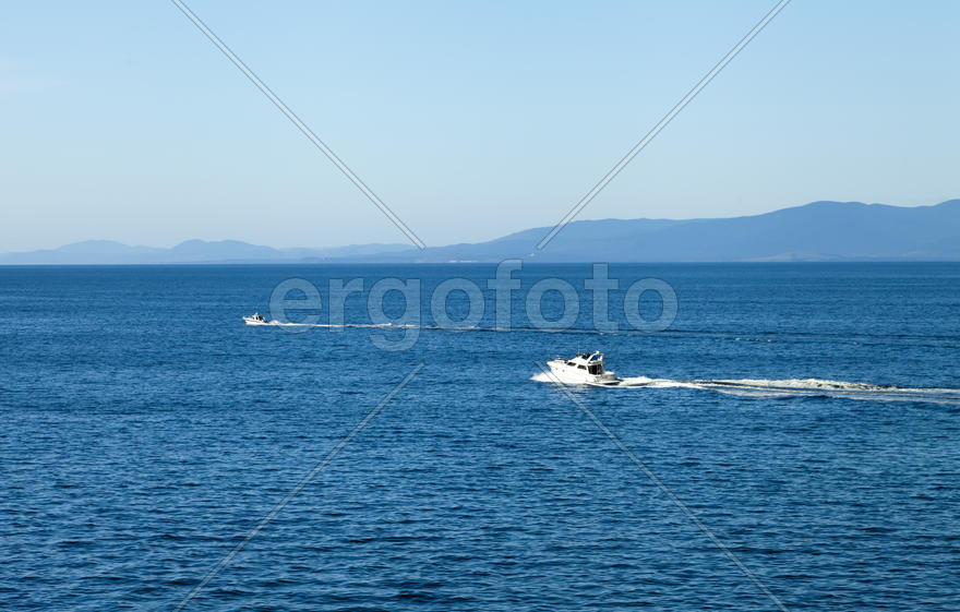 Seascape with ships and mountains on the horizon a bright sunny day