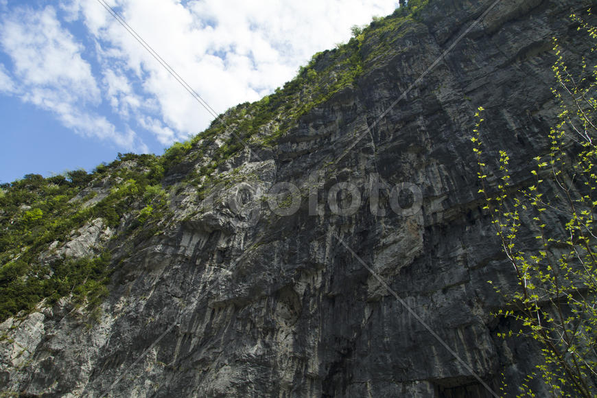 Mountains in the woods and snow are surrounded with clouds