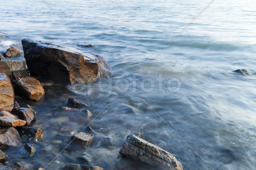 The sea at sunset in beams of the red setting sun