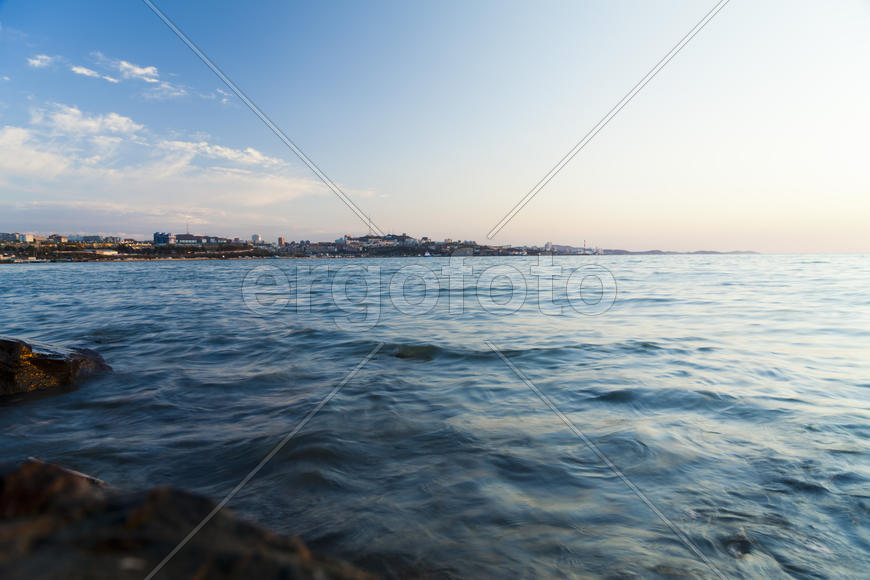 The sea at sunset in beams of the red setting sun