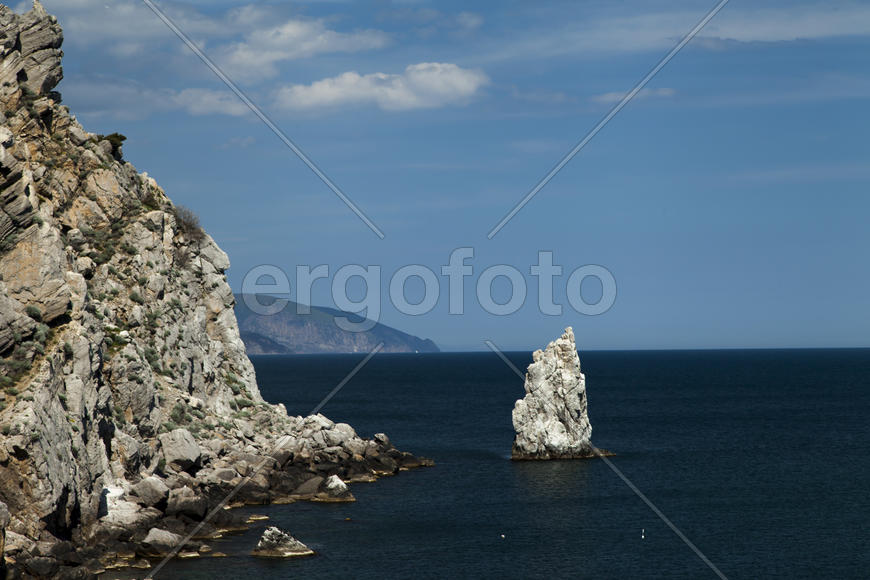 Mountains by the sea in beams of a bright sun