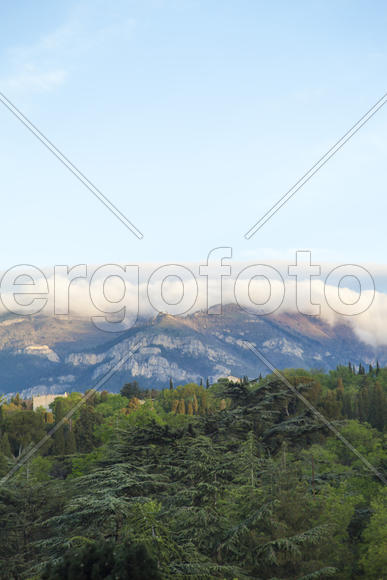 Mountains by the sea at sunrise in beams of the soft sun