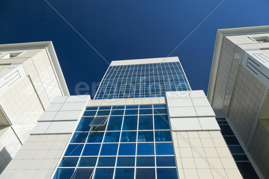 Modern building against the blue sky in the rays of bright sunshine