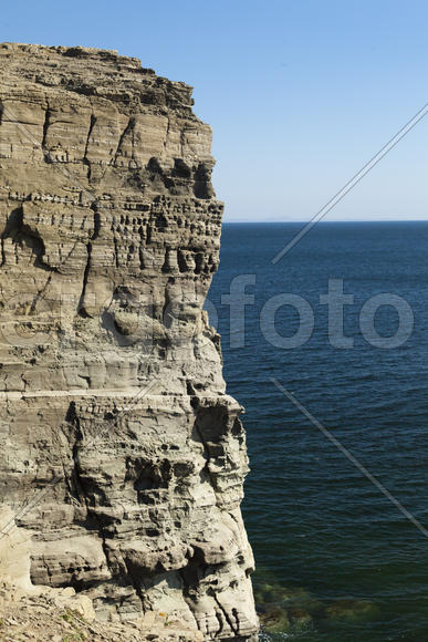 Rocks and sea meet in the bright sunlight in autumn