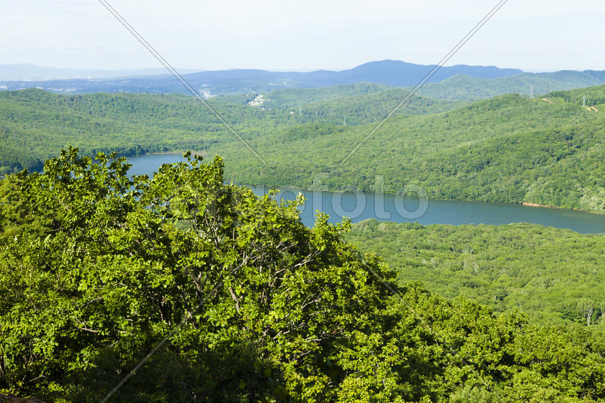 Green hills under the blue sky in beams of a bright sun