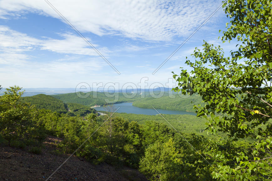 Green hills under the blue sky in beams of a bright sun