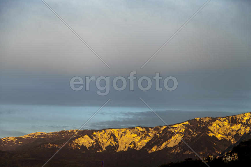 Mountains by the sea in beams of a bright sun