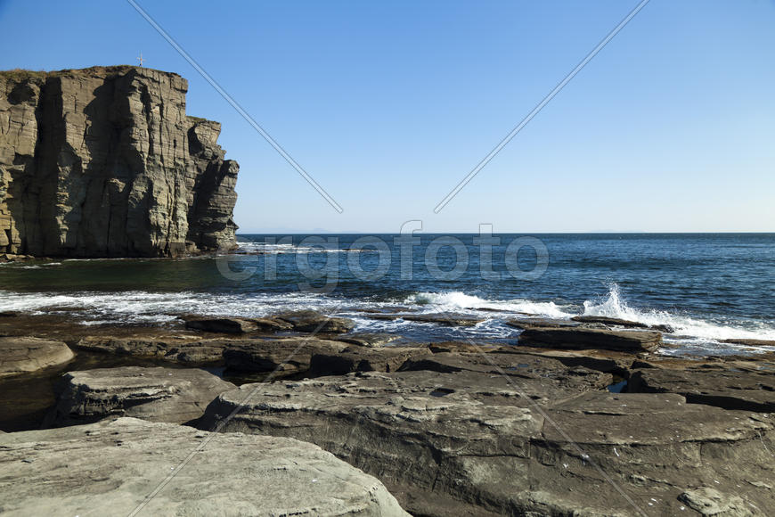 Rocks and sea meet in the bright sunlight in autumn