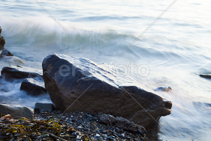 The sea at sunset in beams of the red setting sun