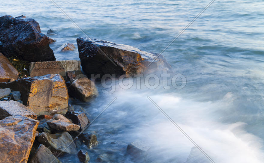 The sea at sunset in beams of the red setting sun