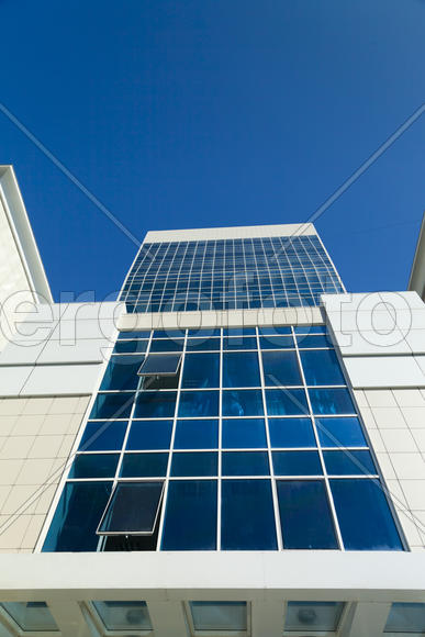 Modern building against the blue sky in the rays of bright sunshine