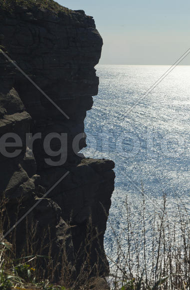 Rocks and sea meet in the bright sunlight in autumn