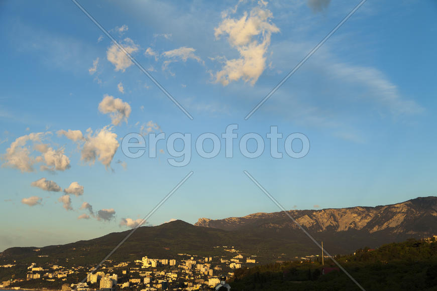 Mountains by the sea at sunrise in beams of the soft sun