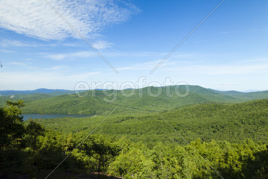 Green hills under the blue sky in beams of a bright sun