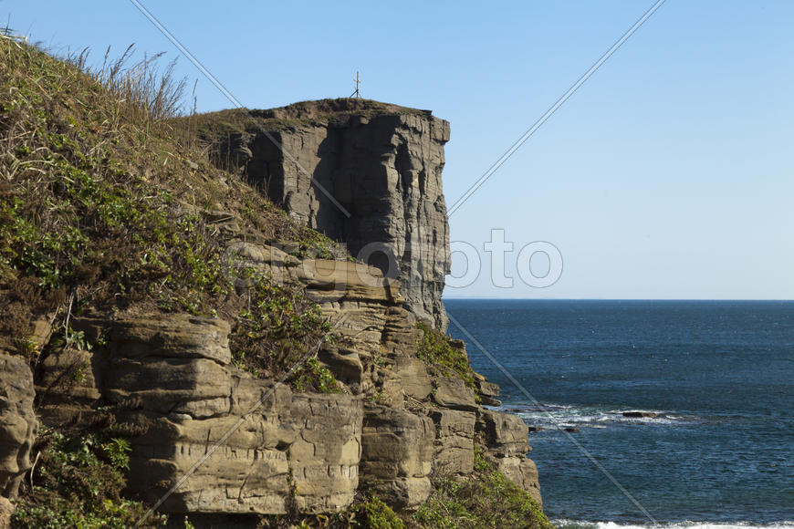 Rocks and sea meet in the bright sunlight in autumn