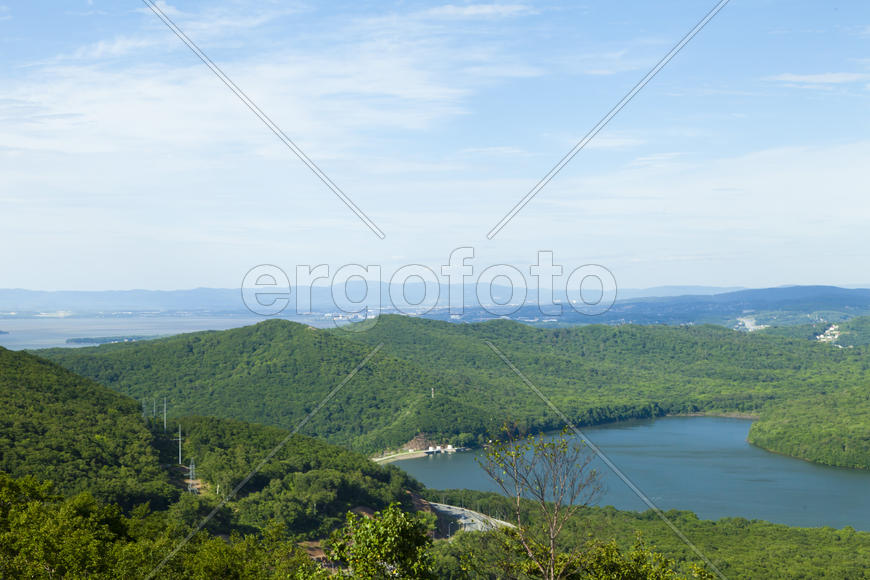 Green hills under the blue sky in beams of a bright sun