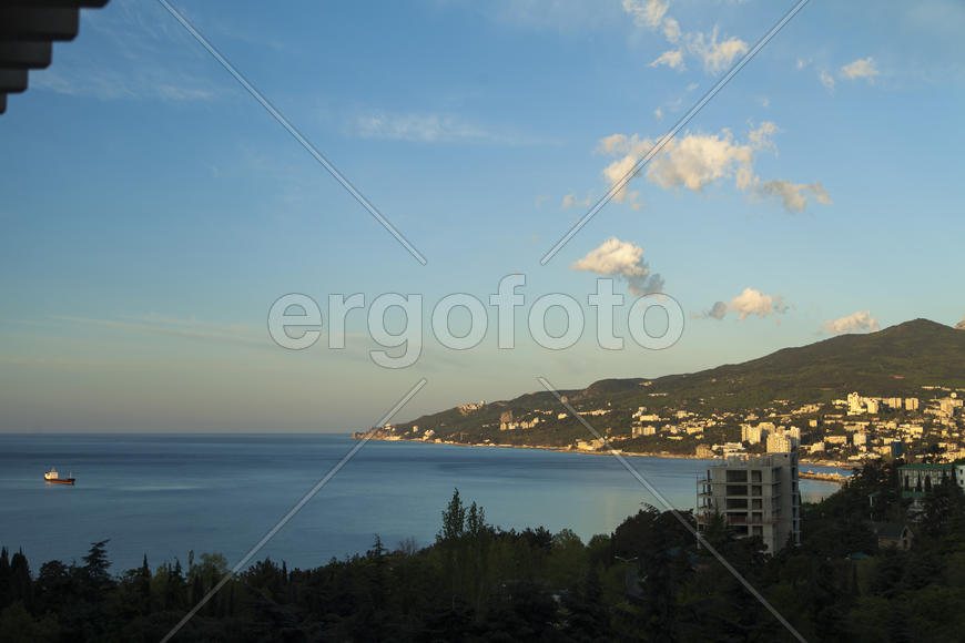 Mountains by the sea at sunrise in beams of the soft sun
