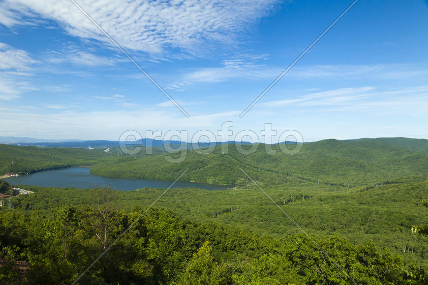 Green hills under the blue sky in beams of a bright sun