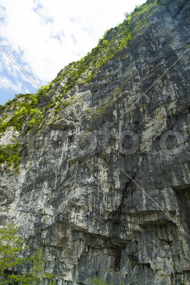 Mountains in the woods and snow are surrounded with clouds