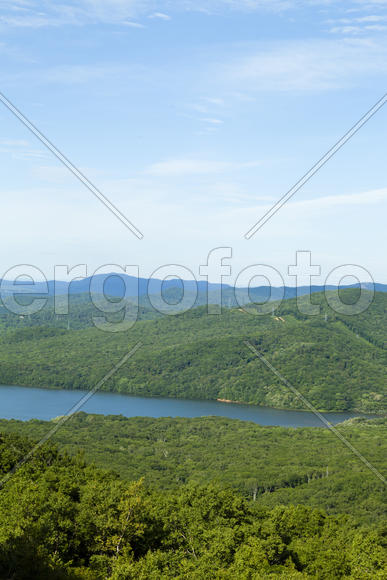 Green hills under the blue sky in beams of a bright sun