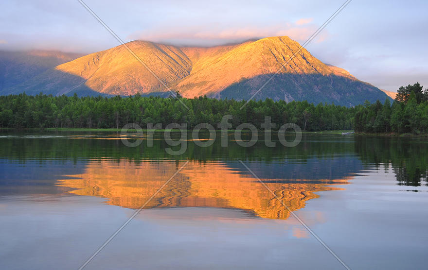 Заходящее солнце освещает гору
