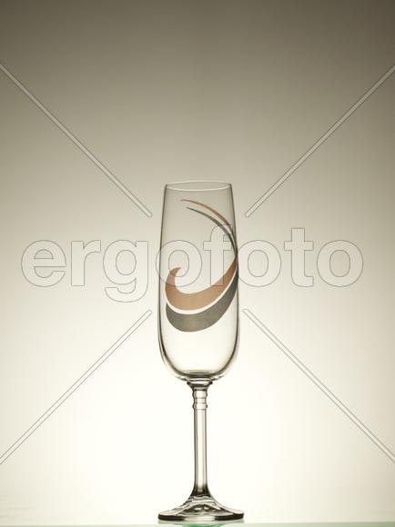 Прозрачный пустой бокал на бежевом фоне 