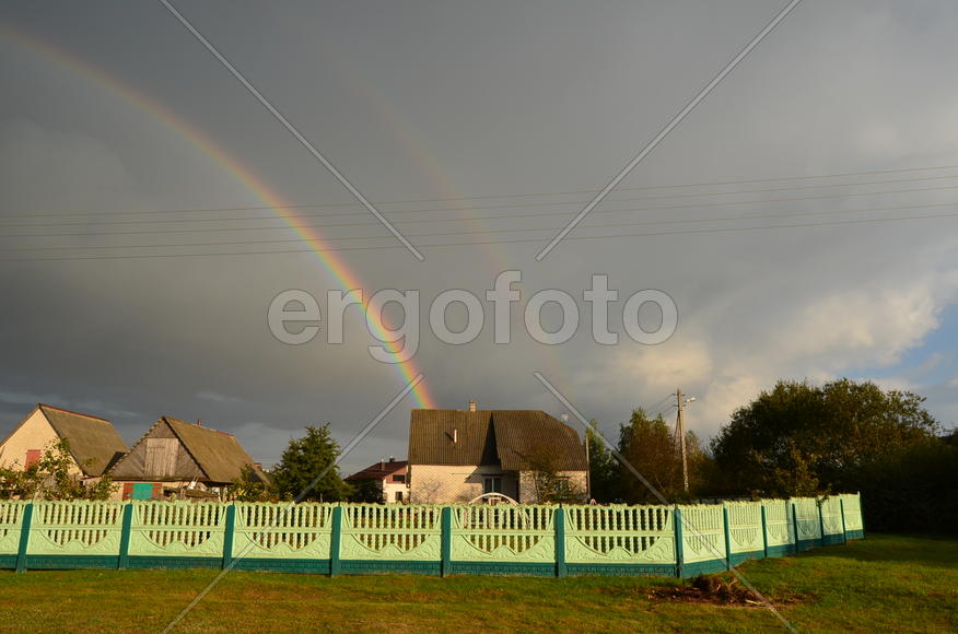 Радуга над деревней и частными домами 
