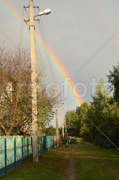 Радуга над деревней и частными домами 
