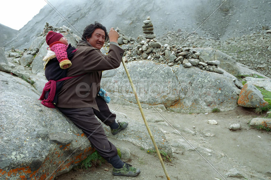 Паломник несет ребенка вокруг Кайлаша.